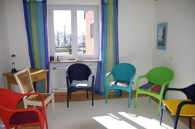 different colored chairs in a room with a window