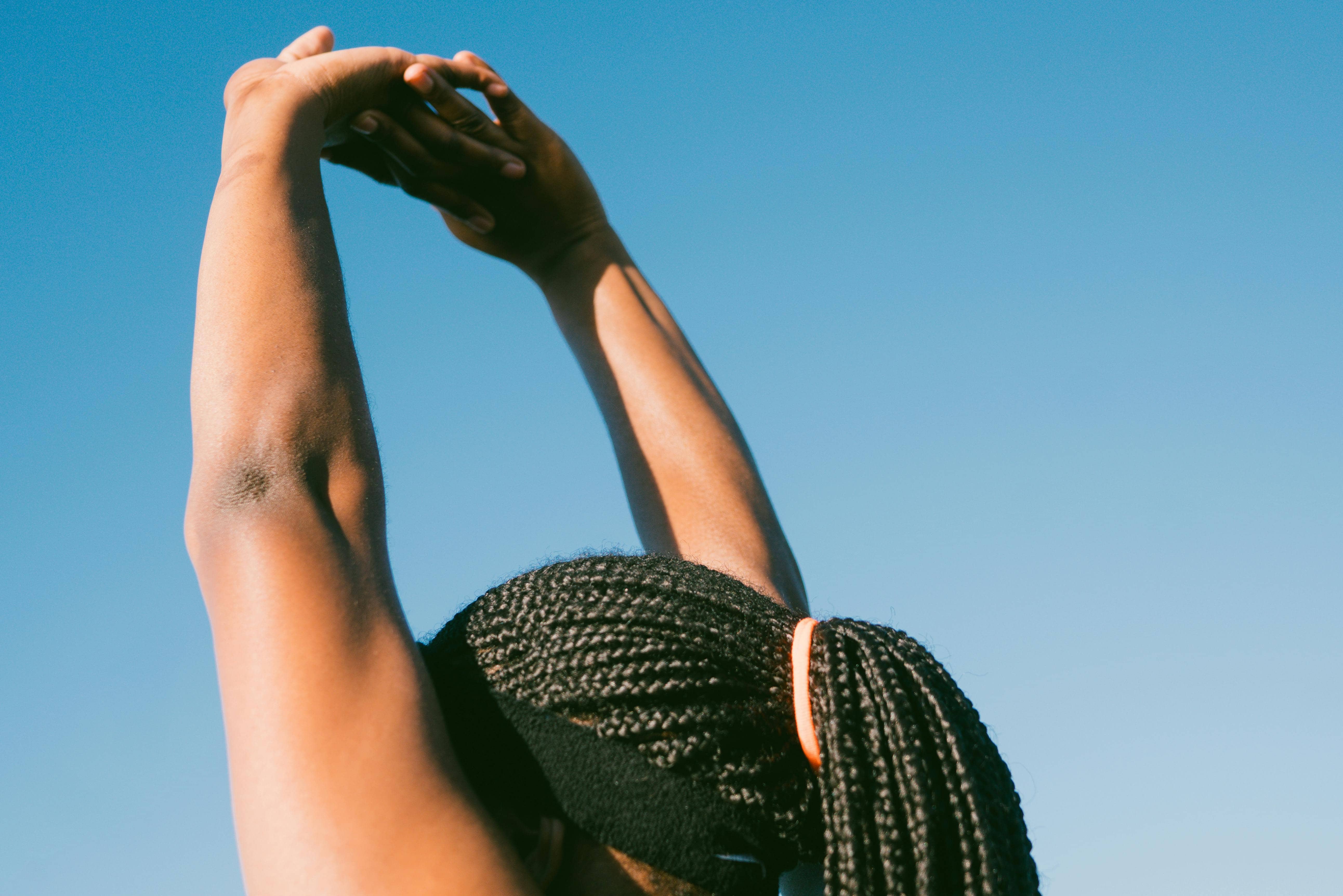 Nashville woman stretching arms in air to represent self care to combat issues with mental health and election anxiety