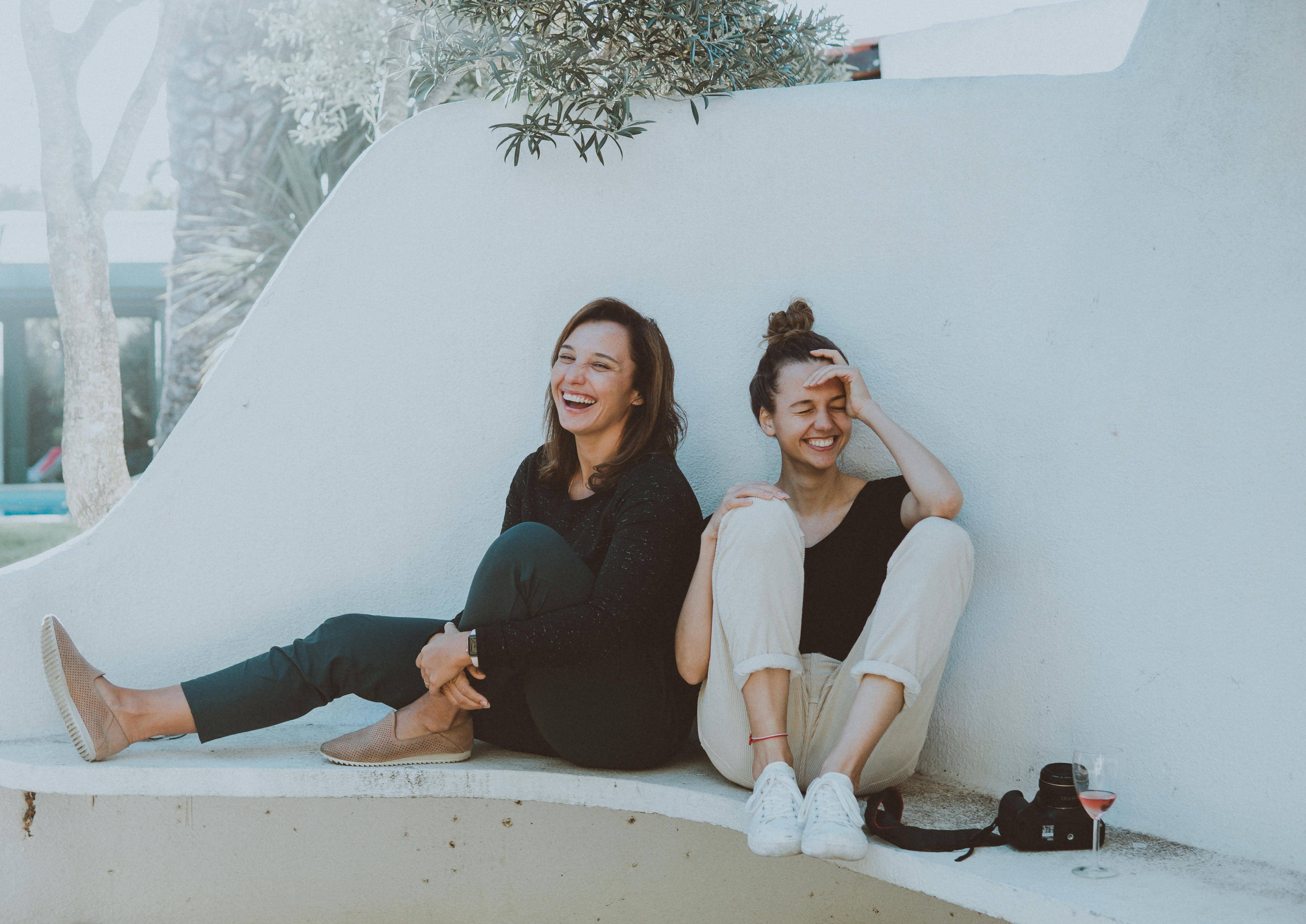 Two Nashville women sitting and laughing to represent self care to combat mental health challenges and election anxiety 